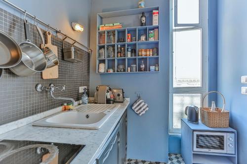 La salle de bains est pourvue d'un lavabo et d'un mur bleu. dans l'établissement Maison Bianchi - 24 Paul Deroulede, à Nice