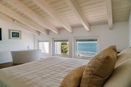 um quarto com uma cama, uma banheira e janelas em NUMA HOTEL em Numana