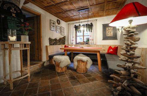 a living room with a table and stools and a room with at Hotel Garni Kirchenwirt in Sankt Leonhard im Pitztal