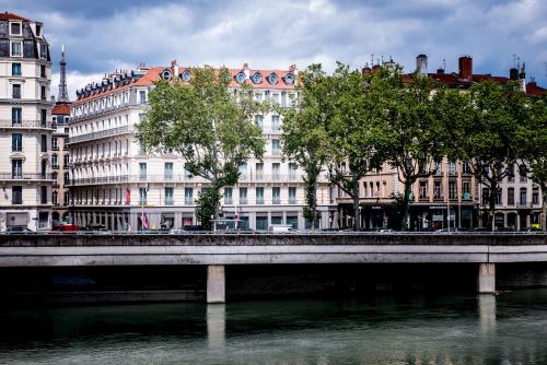 a bridge over a river in front of buildings at Boscolo Lyon Hotel & Spa in Lyon