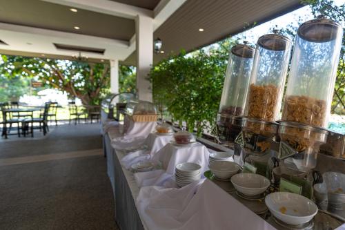 een buffetlijn met borden, kommen en vazen bij Blue Beach Grand Resort And Spa in Rawai Beach
