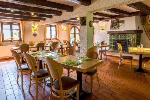 a dining room with tables and chairs and a fireplace at Le Bouton d'Or in Lapoutroie