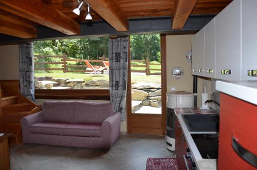 una cucina con sedia viola e finestra di Holiday house with garden and enchanting view a Villeneuve