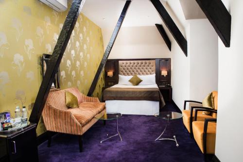a bedroom with a bed and a chair at Great Victoria Hotel in Bradford