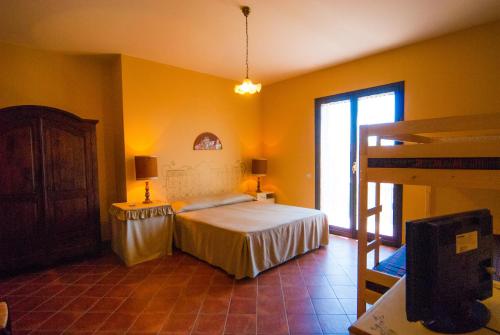 een slaapkamer met gele muren, een bed en een raam bij B&B La Rena Rossa in Nicolosi