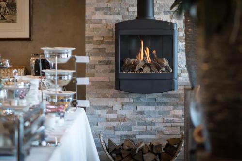 een open haard in een eetkamer met een tafel en een open haard bij Landhotel Heuvelzicht in Schin op Geul