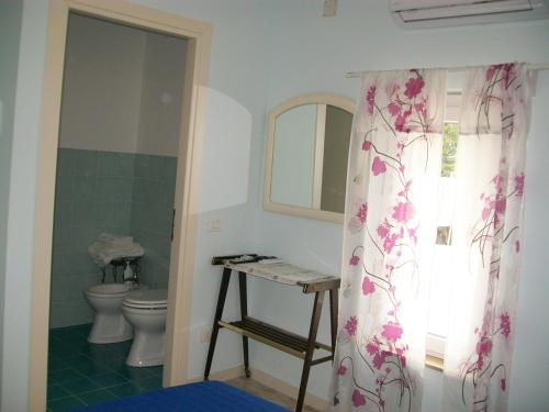 e bagno con servizi igienici e tenda per la doccia. di Affittacamere il girasole a Recanati