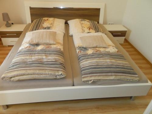 a bed with two pillows on it in a room at Gästehaus Borniger in Gau-Weinheim