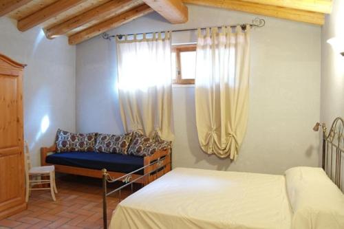 a bedroom with two beds and a window at Agriturismo BioBiò in Vobarno