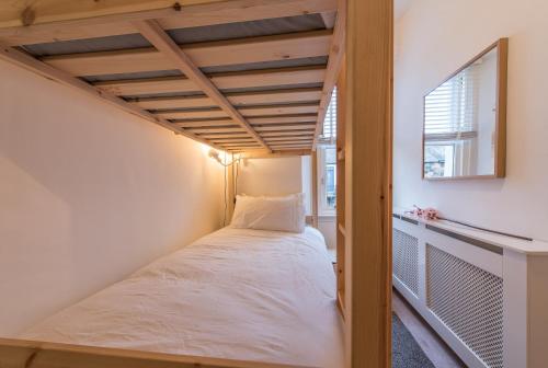 ein kleines Schlafzimmer mit einem Bett in einem Zimmer in der Unterkunft The West End Cottage in Edinburgh