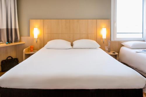 Una cama o camas en una habitación de ibis Lausanne Crissier