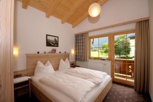 Un dormitorio con una gran cama blanca y una ventana en Chalet Schnee, en Mayrhofen