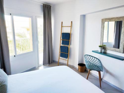 a bedroom with a bed and a ladder and a chair at Apartamentos Las Palmeras in Palmanova