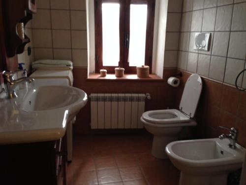 uma casa de banho com um WC, um lavatório e uma janela em Il Borgo 30 em Scapoli