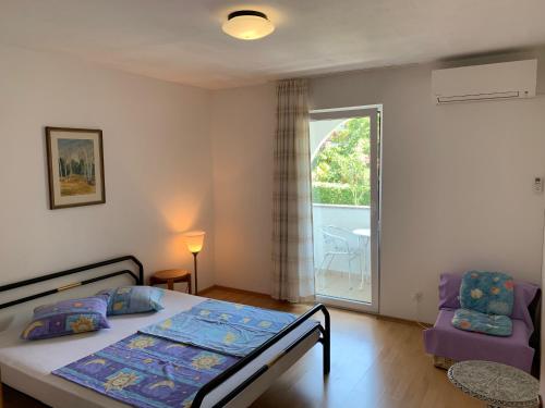 a bedroom with a bed and a window and a chair at Arthouse Villa Palma in Poreč