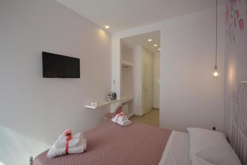 a bedroom with a bed with a tv on the wall at Flower house in Santa Maria La Carità