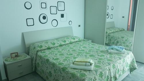 una camera da letto con un letto con uno specchio sopra di Villetta nella Baia a Furnari
