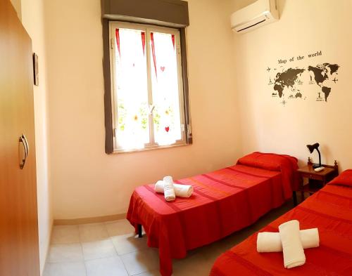 マリーナ・ディ・モーディカにあるSplendida villetta sul mareの赤いシーツと窓が備わるベッド2台付きの客室です。