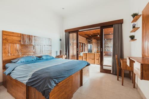 a bedroom with a large bed with a wooden headboard at Big Brother Berawa Beach in Canggu