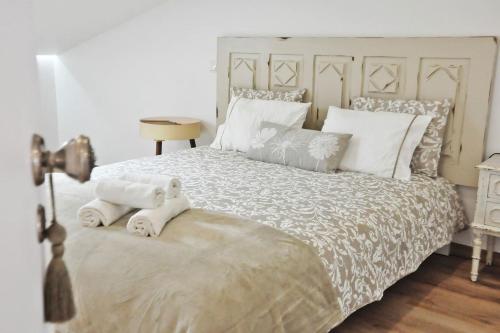 a bedroom with a large bed with white sheets and pillows at Loft acolhedor em Fátima perto do Santuário in Fátima