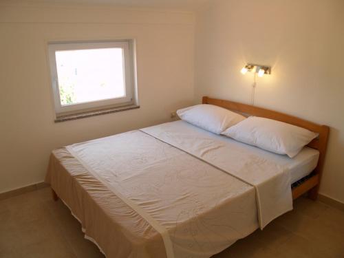 a bed with two pillows and a window in a bedroom at Villa Majer in Preko