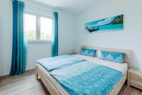 a bedroom with a bed with blue sheets and a window at Ferienwohnung Salzgrotte in Eggolsheim
