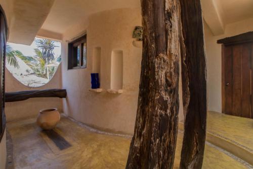 a room with a vase sitting on the floor at La Posada del Sol Boutique Hotel Tulum in Tulum