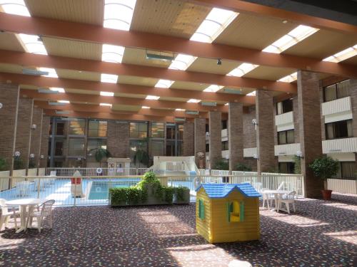 a building with a pool and a building with a dog house at Clarion Hotel & Conference Center Lansing West in Lansing