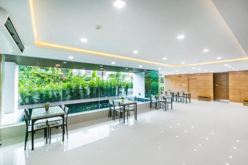 a restaurant with tables and chairs and a large window at ตะวันอพาร์ทเม้นท์โฮเทลThawanapartmentHotel in Satun