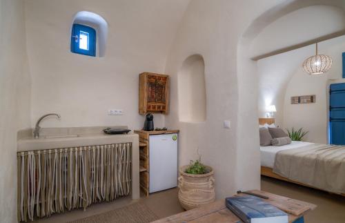 a kitchen with a sink and a bed in a room at Nalas Suites in Emporio Santorini