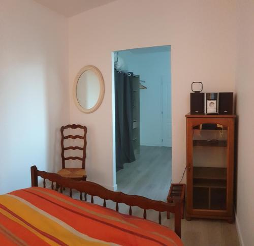 - une chambre avec un lit, un miroir et une commode dans l'établissement Appartement hyper-centre Epernay avec sauna et parking privé, à Épernay