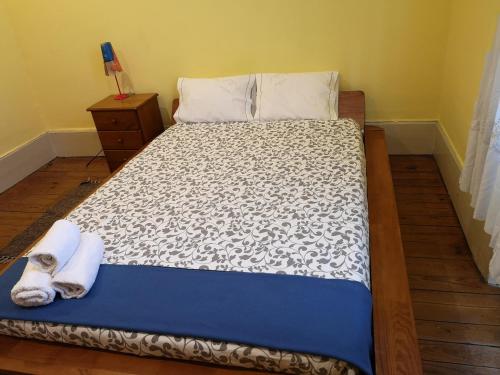a bedroom with a bed with a blanket and a dresser at Guesthouse Monsanto in Porto