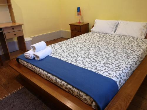 a bed with a white bedspread and pillows on it at Guesthouse Monsanto in Porto