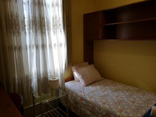 a small bedroom with a bed and a window at Guesthouse Monsanto in Porto