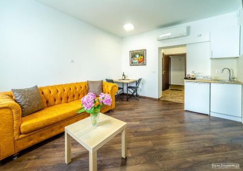 un salon avec un canapé et une table avec des fleurs dans l'établissement Urania Apartments, à Ohrid