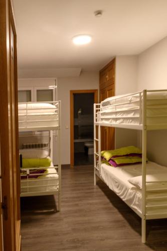 a room with three bunk beds and a hallway at Hostel Catedral Burgos in Burgos