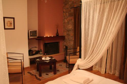a living room with a couch and a television at Karyatis Resort in Synikia Mesi Trikalon