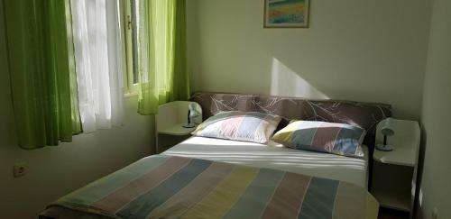 ein Schlafzimmer mit einem Bett mit zwei Kissen darauf in der Unterkunft Tanja in Opatija