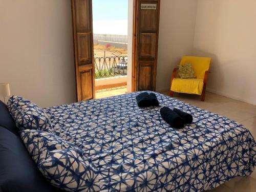 een slaapkamer met een bed, een stoel en een raam bij Apartamento Puerto de Sagunto Playa in Puerto de Sagunto