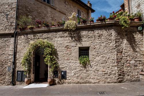 a brick building with flowers on a balcony at Hotel Sole in Assisi