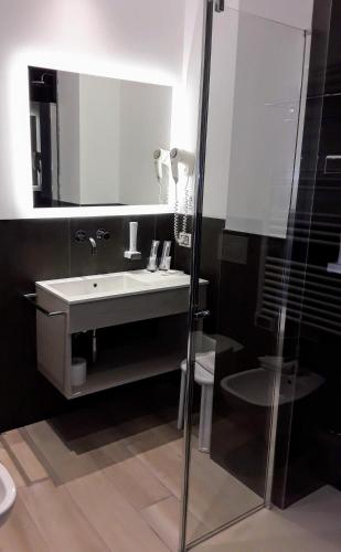a bathroom with a sink and a mirror and a toilet at Hotel Danieli La Castellana lago di Garda in Brenzone sul Garda