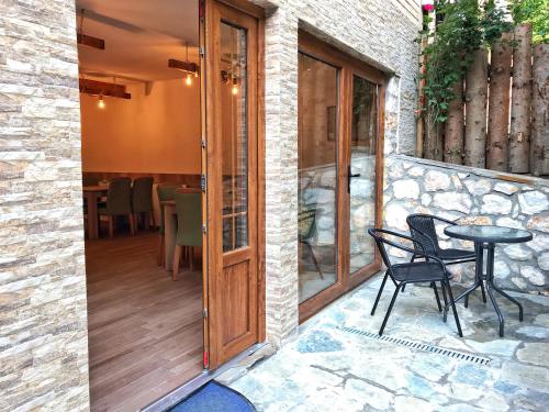 a glass door leading to a patio with a table and chairs at Chalet Kujta in Peje