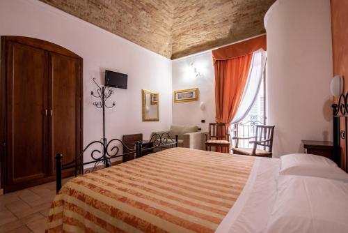 a bedroom with a bed and a living room at Hotel Sole in Assisi