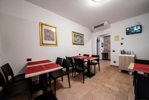 a dining room with red tables and black chairs at Hotel Sole in Assisi