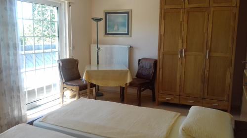 ニュームブレヒトにあるHaus Papst Johannes Paul. II.のベッドルーム1室(ベッド1台、テーブル、椅子付)