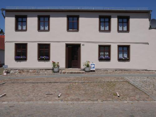a white building with windows and a door at Alte Schmiede Sagard in Sagard