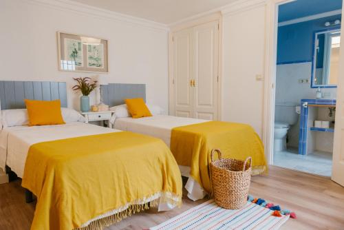 - 2 lits avec des draps jaunes dans une chambre dans l'établissement Cordoba COol Vailima, à Cordoue
