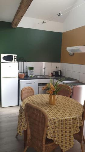 une cuisine avec une table et des chaises ainsi qu'une cuisine avec une table et une table dans l'établissement La clef des champs 3, à Meillac