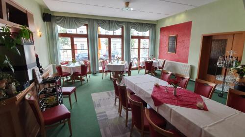 ein Esszimmer mit Tischen und Stühlen in einem Restaurant in der Unterkunft Hotel Stadt Magdeburg in Perleberg