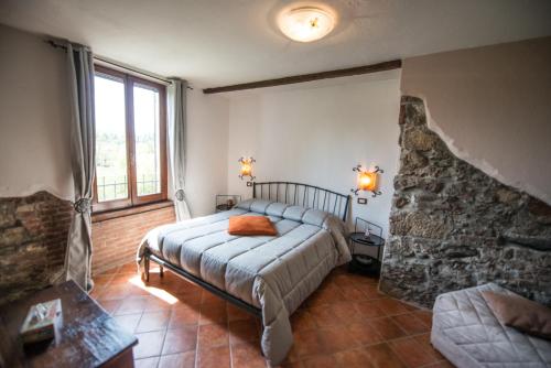 um quarto com uma cama e uma parede de pedra em B&B Borgo Cortese em Gavi